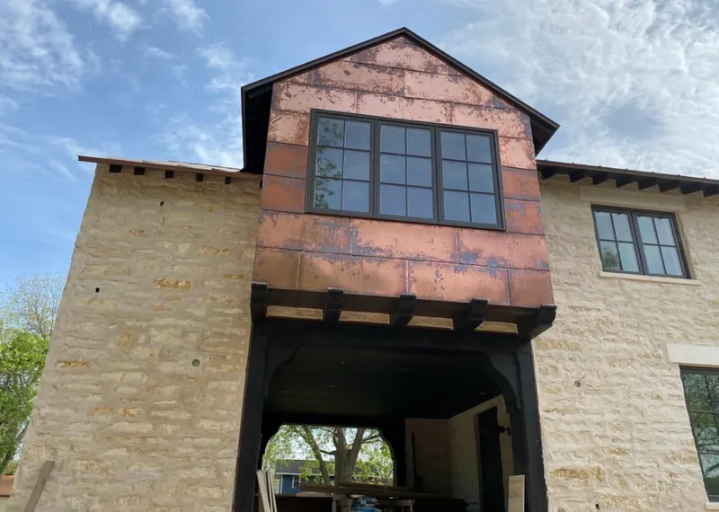 Copper metal panel facade on a stone building for Skylight Installation in Wellsville