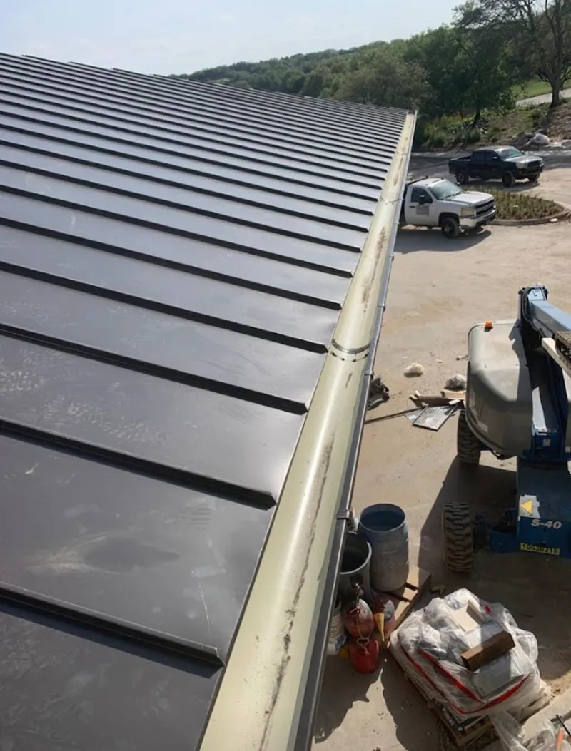 Standing seam panel and gutter detail on a metal roofing jobsite in Wellsville